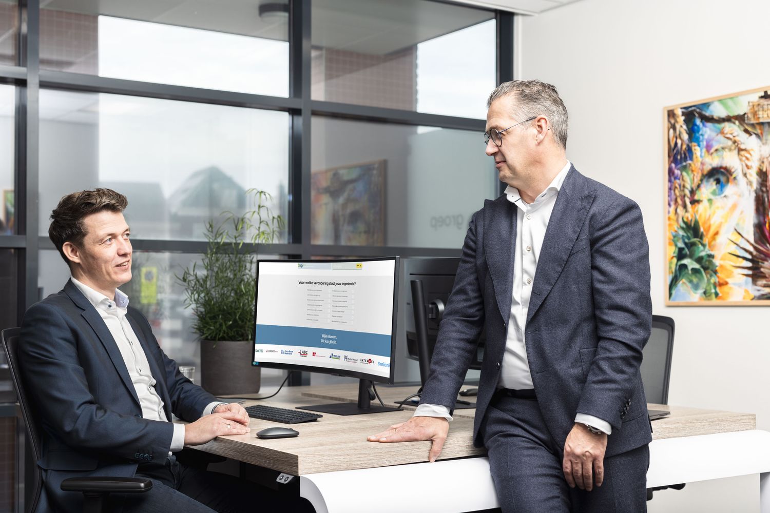 Overleg aan het bureau met een scherm